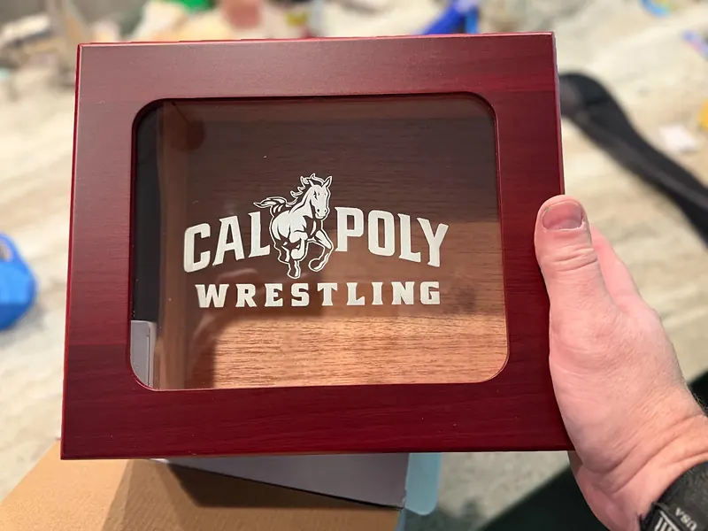 The rosewood finish humidor with a glass lid engraved Cal Poly Wrestling